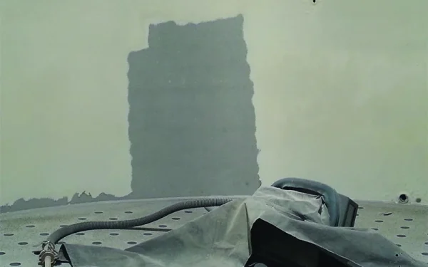 Sloopwerkzaamheden aan hoog gebouw met graafmachine en bouwmaterialen op de voorgrond