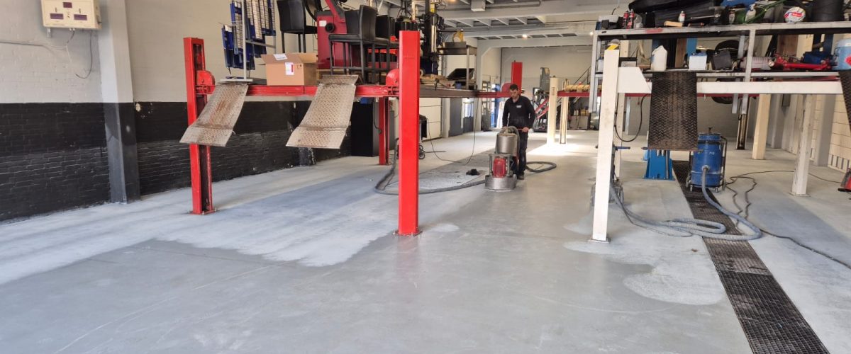 Professionele autowerkplaats met rode hefbruggen en gespecialiseerde reparatievoorzieningen