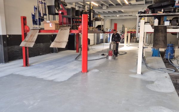 Professionele autowerkplaats met rode hefbruggen en gespecialiseerde reparatievoorzieningen