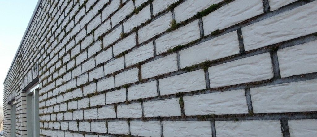 Moderne gevelrenovatie met grijze bakstenen in halfsteens verband, professioneel metselwerk met strakke voegen