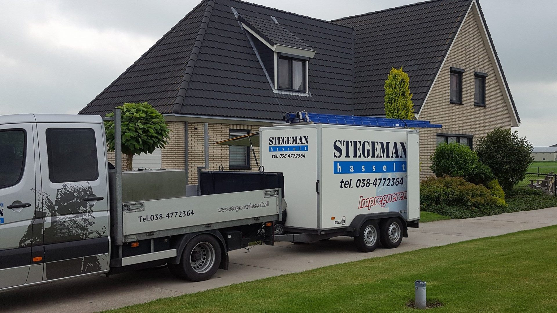 Airconditioning installatie bij woonhuis met servicevoertuigen en aanhangwagen van installatiebedrijf